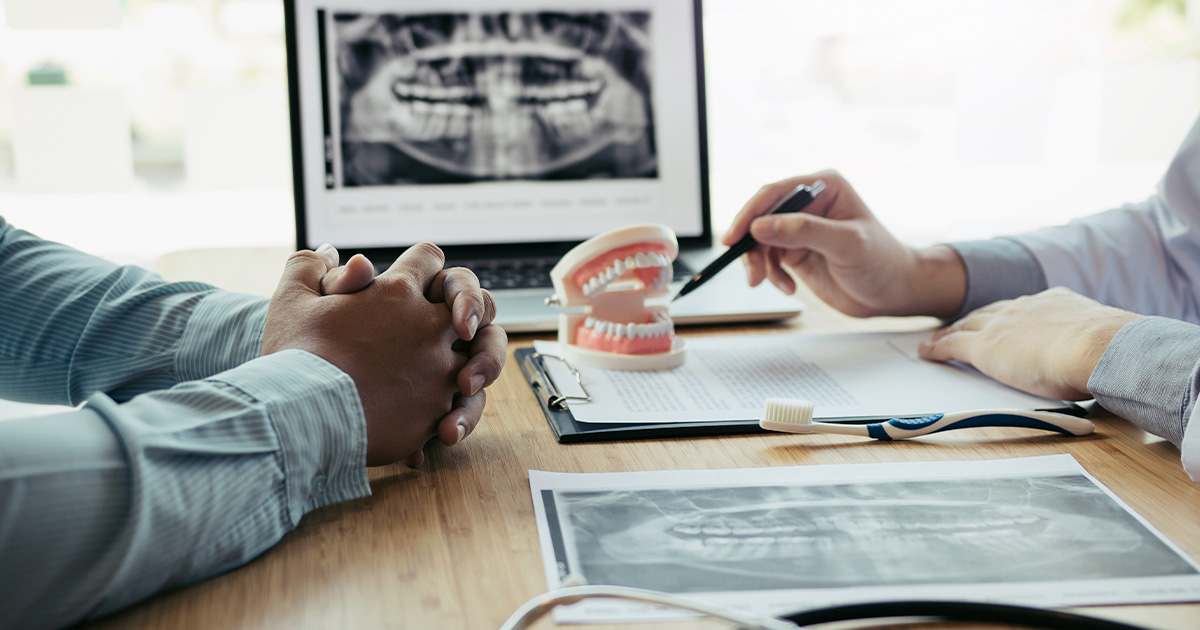 Closeup of hands reviewing a set of dental implants on a desk